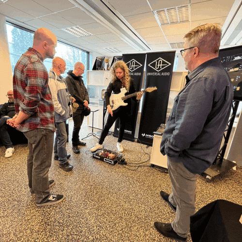 Jyrki Mäkinen ja muutama messuvierassa kerääntyneenä Markus Venehsalon ympärille hänen esitellessään sähkökitara kaulassaan Universal Audion UAFX-pedaaleja.