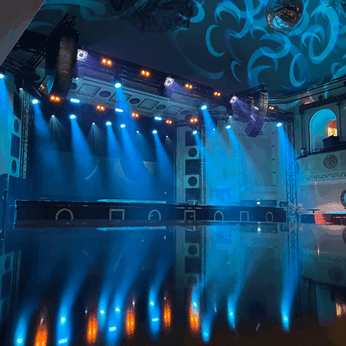 Sinertävästi valaistu Apollo Live Clubin lava Adamson IS-sarjan line array -kaiuttimineen