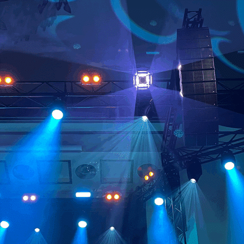 Minuit Une IVL Dice ja Adamson IS-sarjan line array -kaiuttimet sinertävästi valaistun Apollo Live Clubin trussissa
