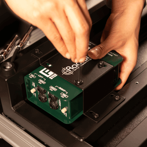 Kädet asentamassa Radial Engineering TrainTrack Plus:aa pedaalilautaan.