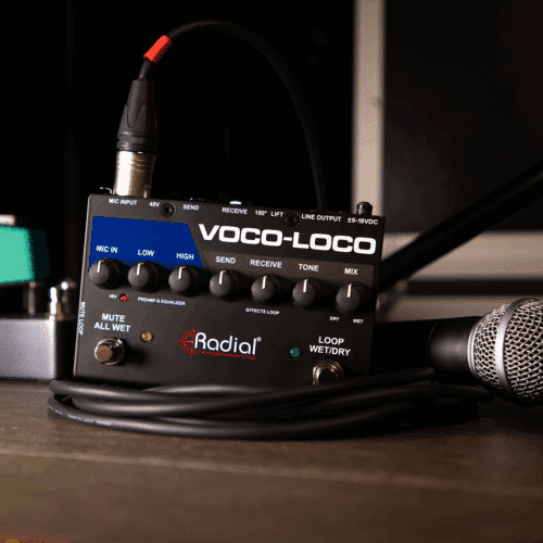 Radial Engineering Voco-Loco Mk2 pöydällä, vieressä mikrofoni ja efektipedaaleja.