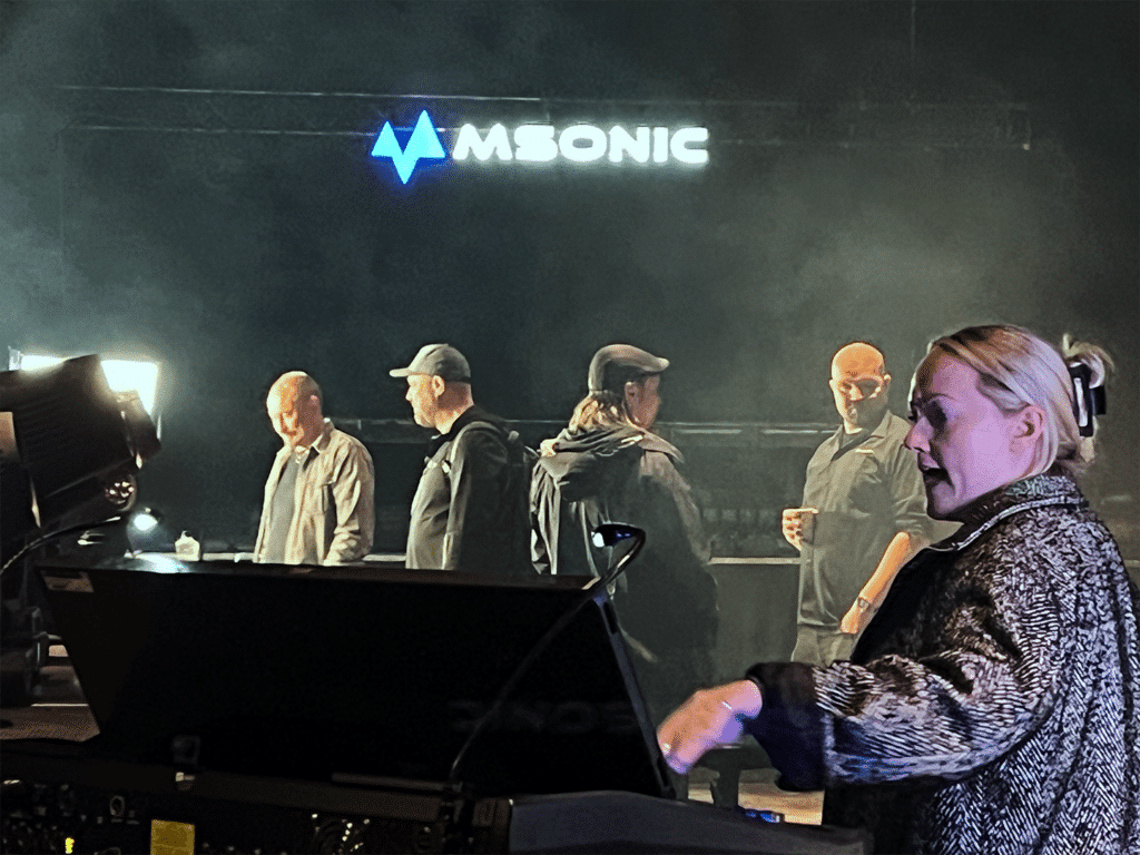 Amy Kerr operoi valotiskiä ihmisten keskustellessa taustalla.