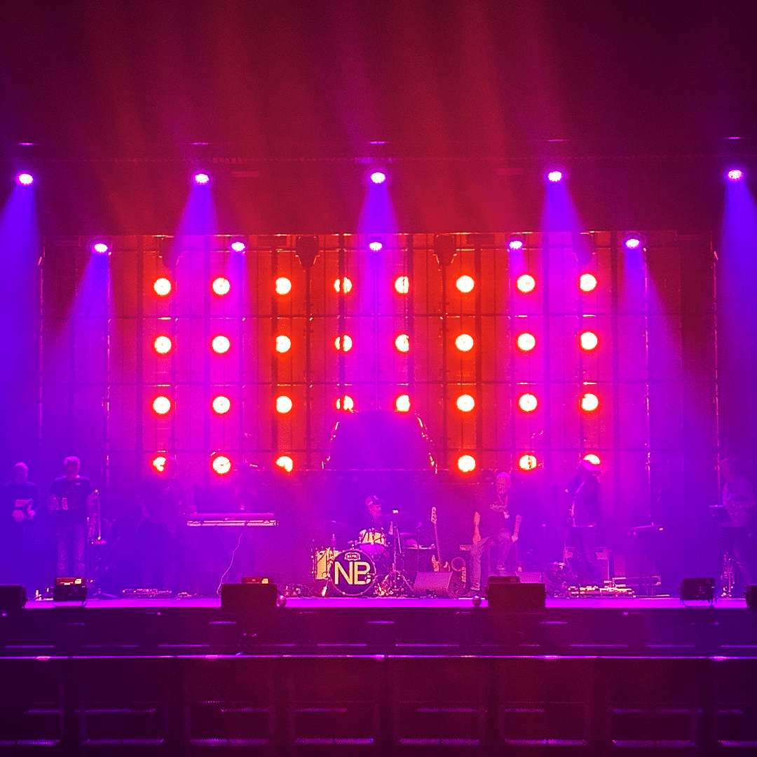 Nylon Beatin bändi valmistautumassa lavalla ennen Tytöt haluaa -konserttia puna-sinisessä valaistuksessa.